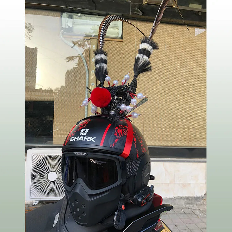 Motorcycle helmet with a gold crown and long feather decoration attached to the side.