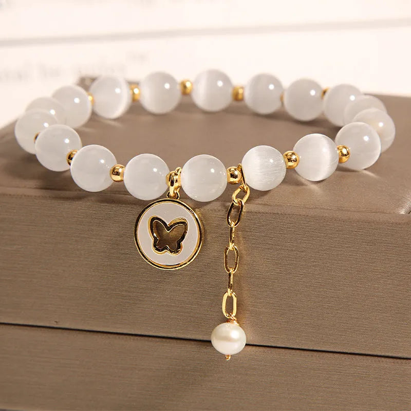 White Cat's Eye crystal bracelet with geometric links on a wrist.