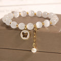 White Cat's Eye crystal bracelet with geometric links on a wrist.