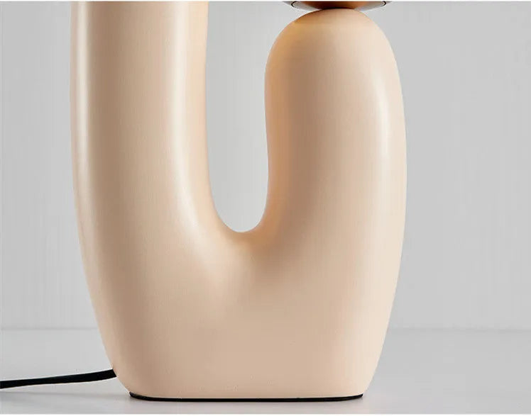 Pink double-head resin table lamp with glass shade on a bedside table, 49cm tall