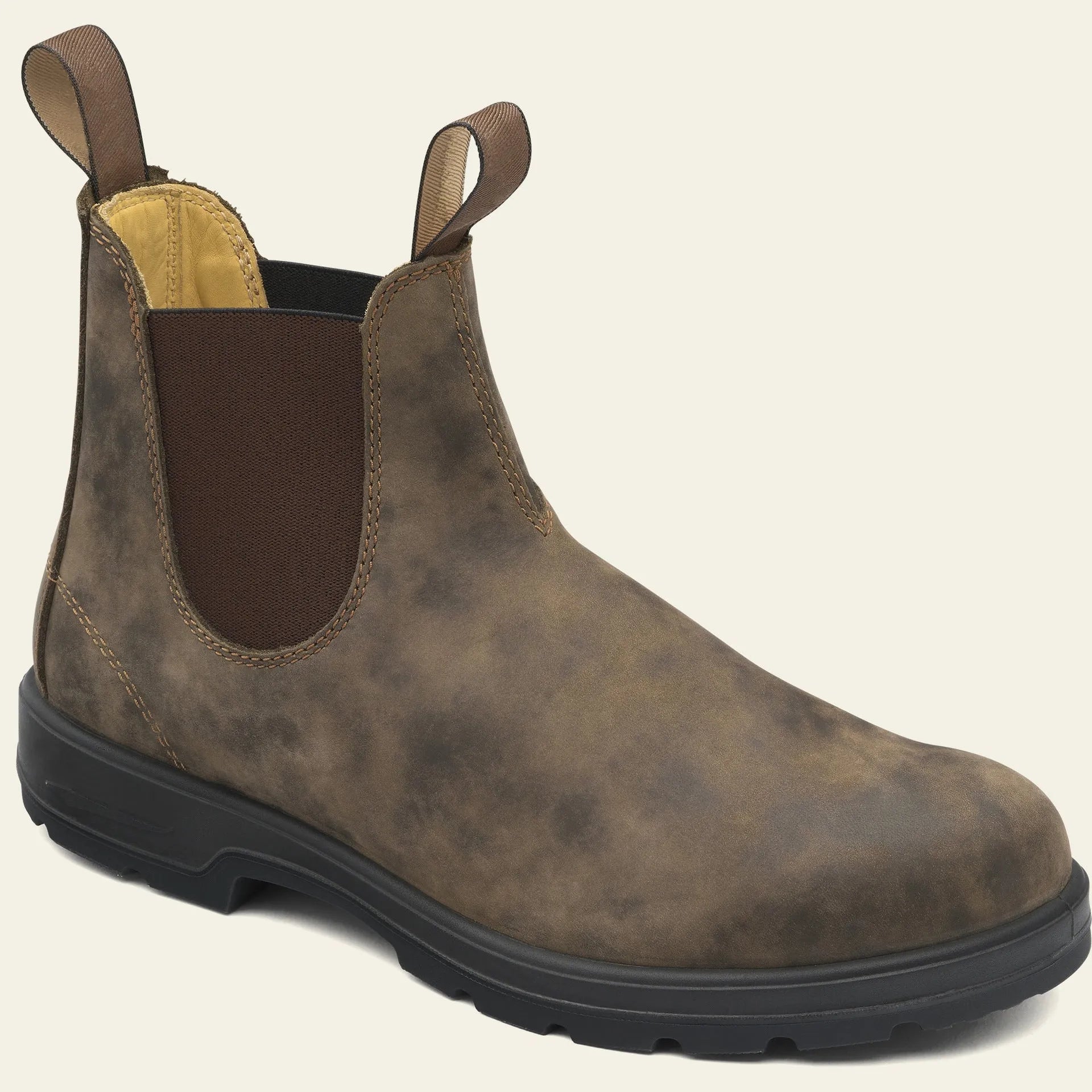 Vintage frosted brown leather Chelsea boots with round toe and car suture detailing on a wooden floor.