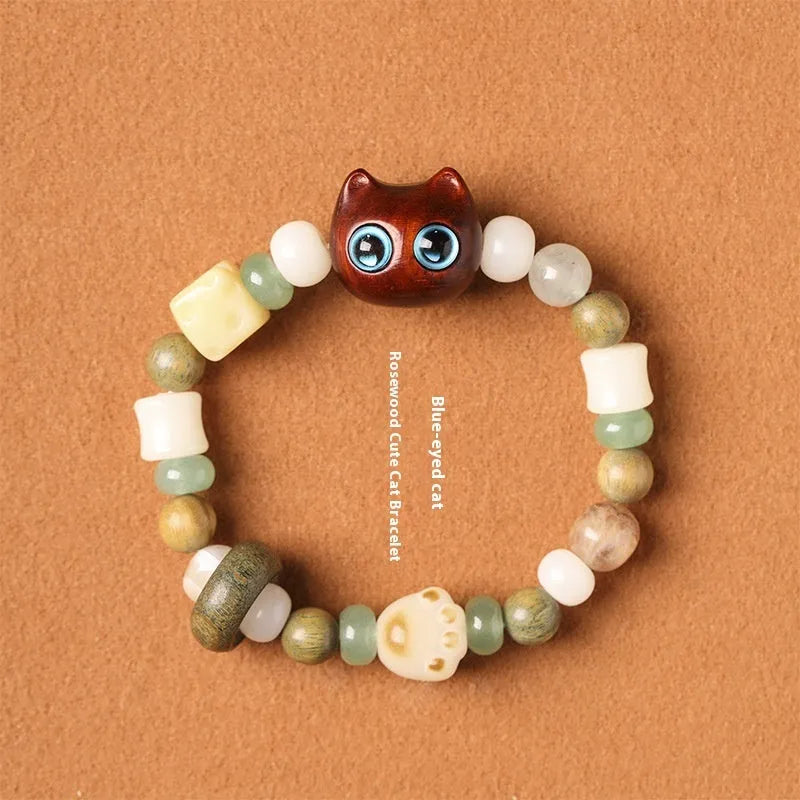 Hand-woven multi-treasure bracelet with Bodhi seeds, jade, and wood beads featuring a cat's paw charm.