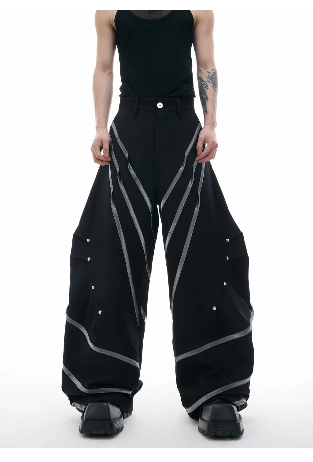 Men's polyester trousers with pleats and metal rivet detailing, shown in black and white colour options.