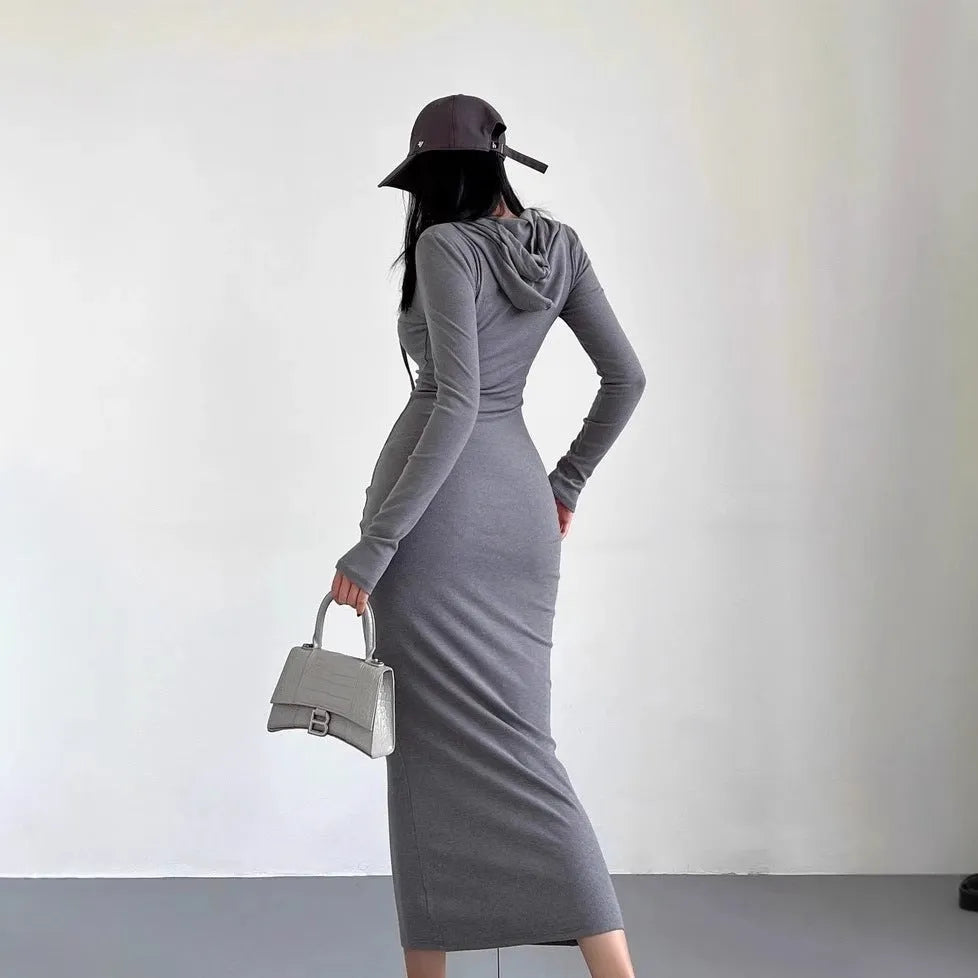 A woman's light grey hooded sheath dress with long sleeves, high waist, and over-the-knee length.