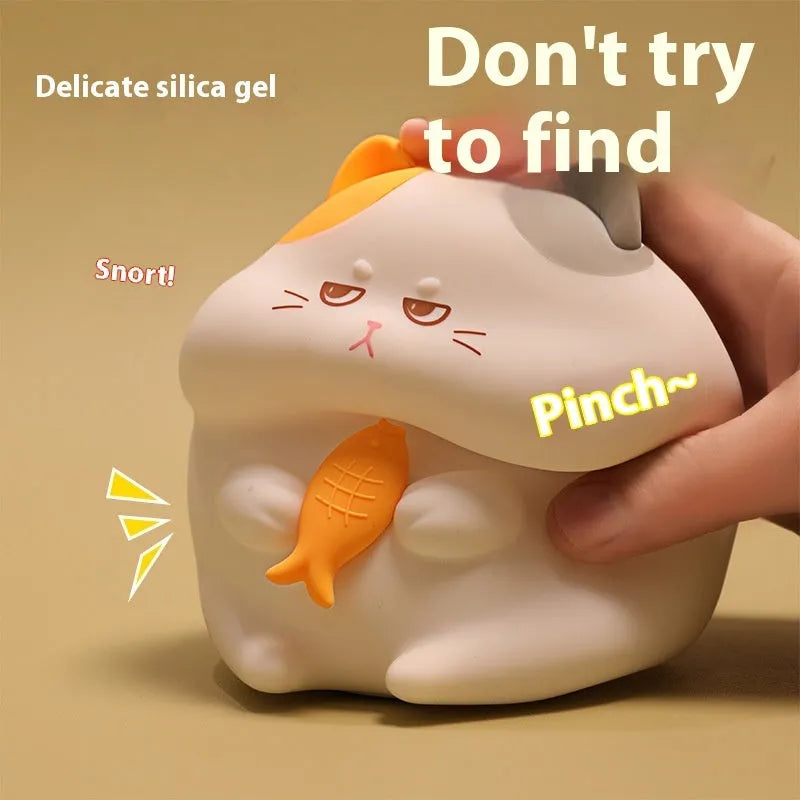 Small yellow Greedy Cat cartoon night light on a desktop, showing fish theme and compact size.