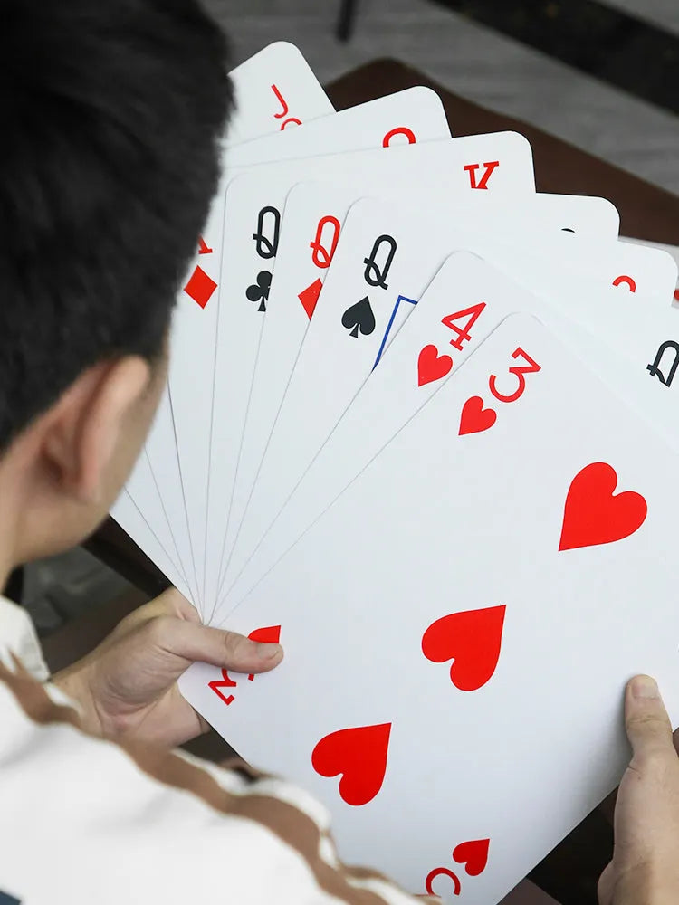 Set of oversized large size paper playing cards laid out on a table, showing the full 54-sheet deck.