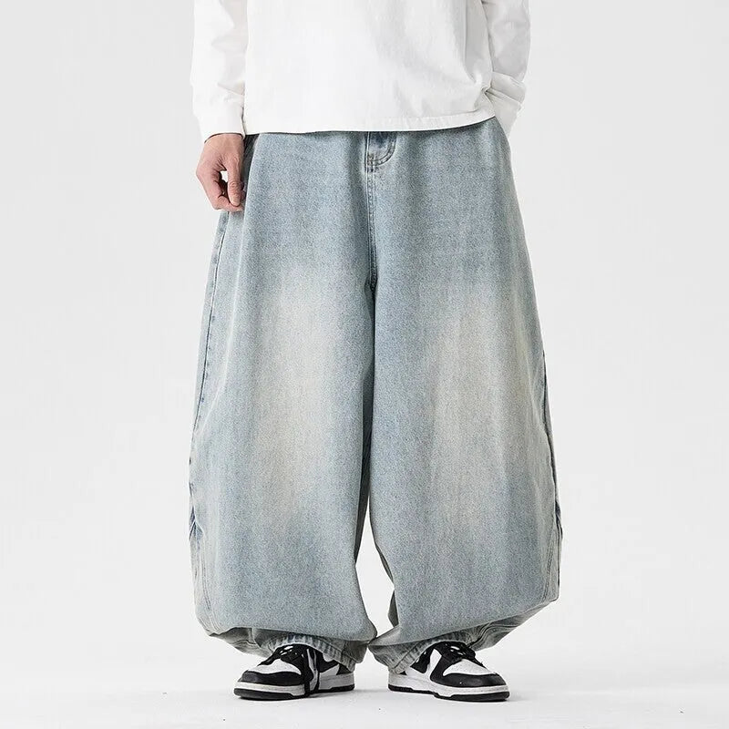 Men's plus-size light blue wide-leg baggy denim jeans on a hanger.