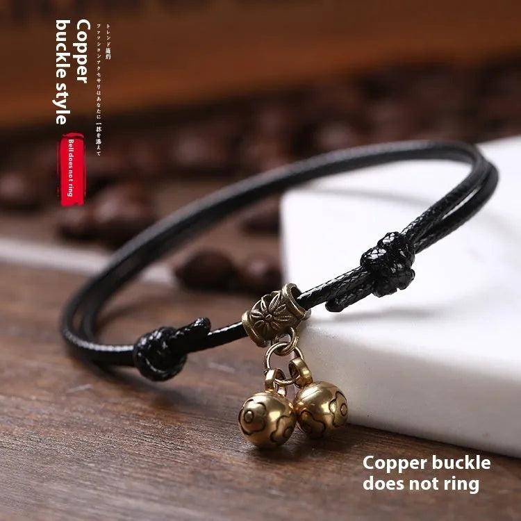Adjustable black nylon dog collar with a brass bell for a small pet.