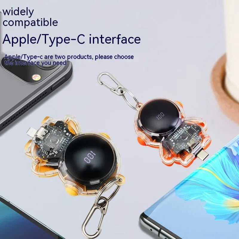 Small keychain emergency power bank in orange plastic shell with cartoon-style design and keyring attachment