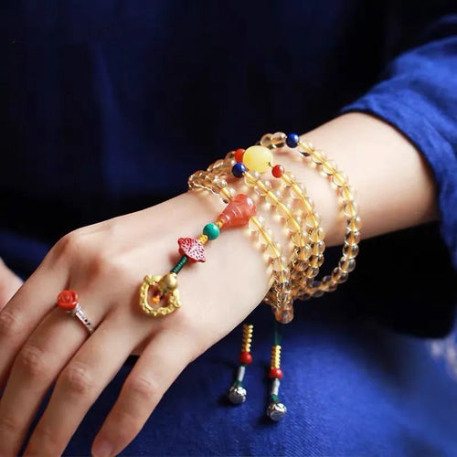 Yellow natural citrine bracelet with 1mm beads and filament accessory details on a wrist.