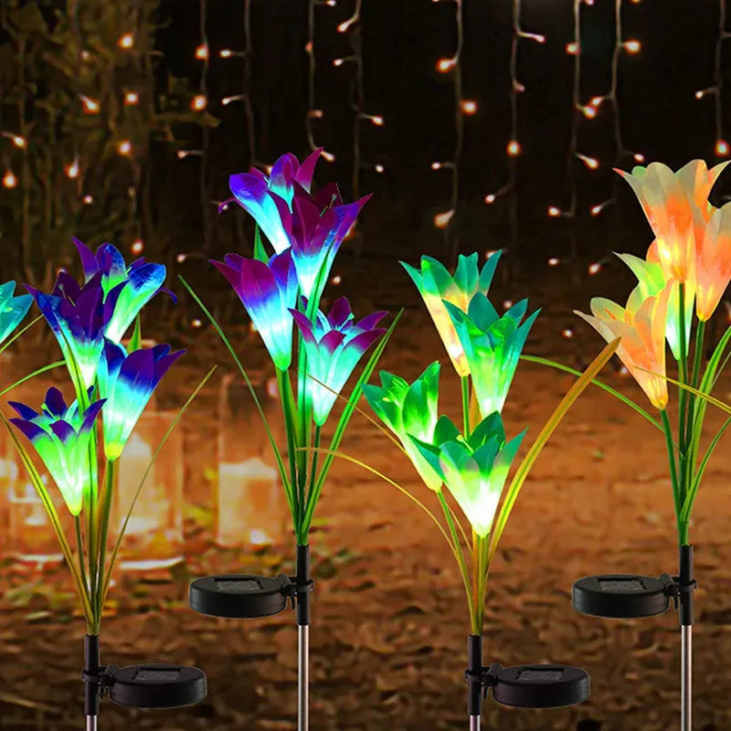 Solar lily flower light with silk cloth head, colour-changing LEDs, and stainless steel stake in a garden setting