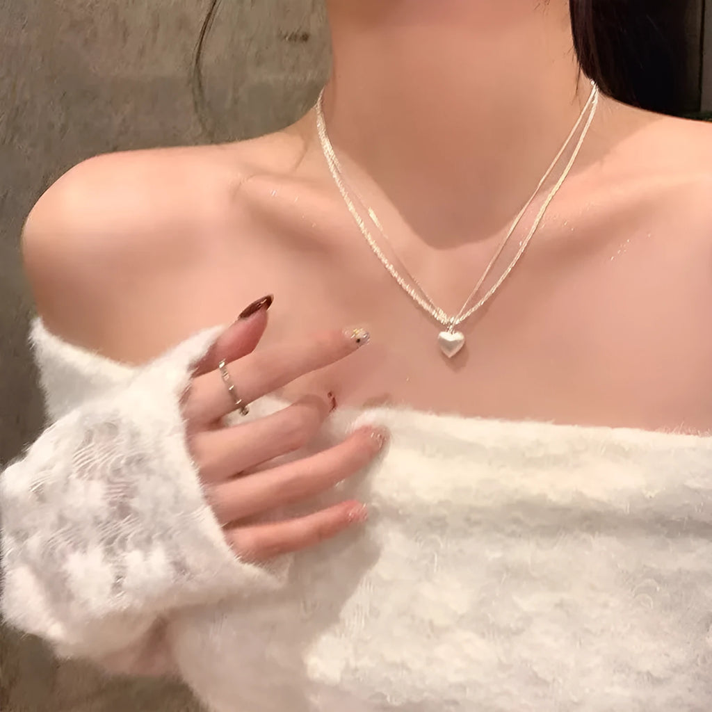 Double layer brushed heart shaped pendant necklace on adjustable silver tone chain.