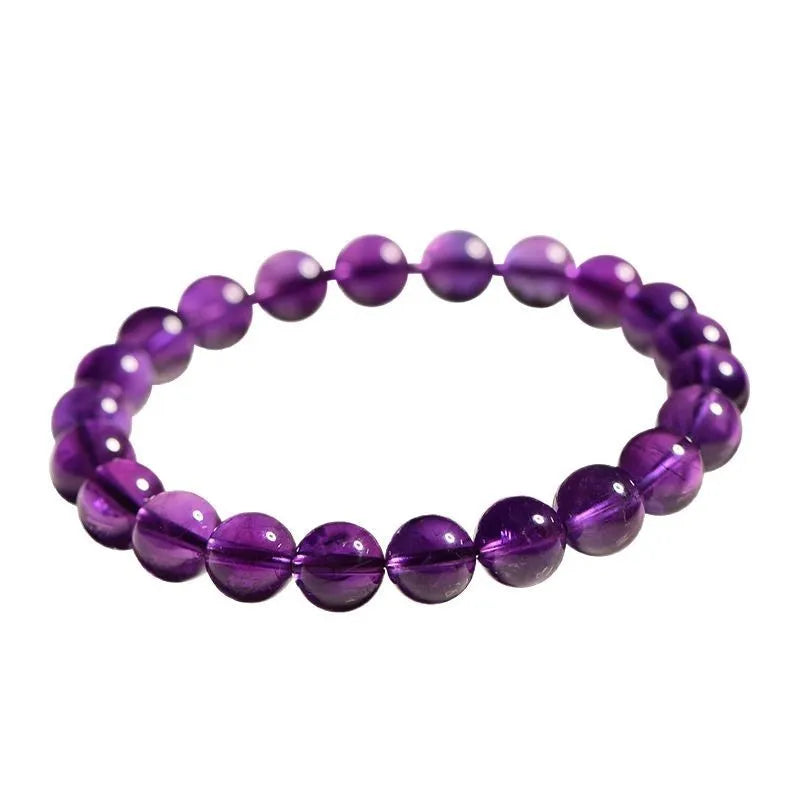 Natural amethyst Uruguay bracelet with scattered polished beads on a white background.