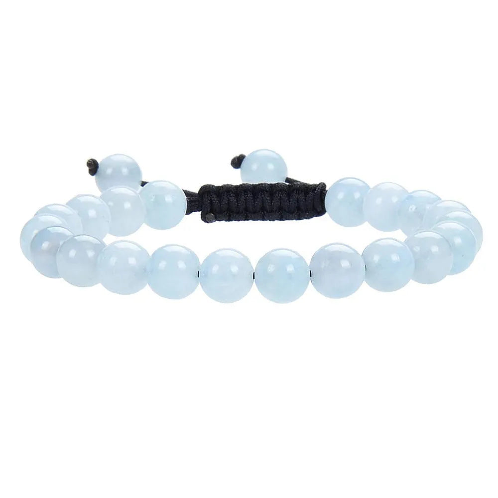 Close-up of a hand-woven flat knot braided bracelet with assorted gemstone beads on a female wrist.