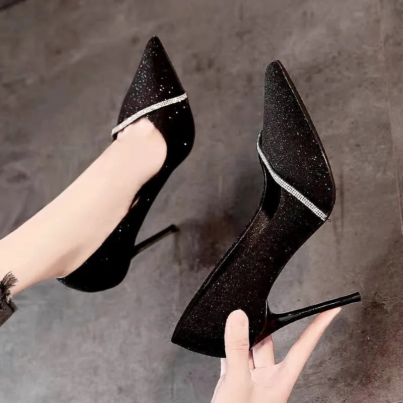 Gold women's pointed toe stiletto high heels with a low cut design on a plain background.
