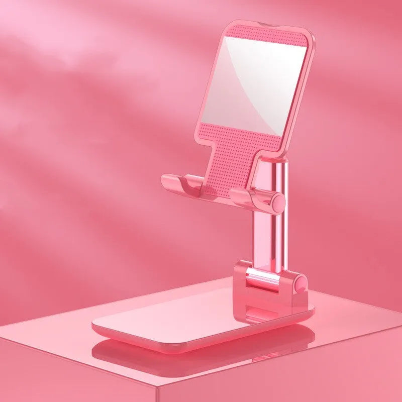 White folding telescopic mobile phone bracket holding a smartphone on a desktop.