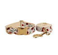 Red cherry print dog collar and leash set with light gold buckle, matching vest, bow, and poop bag holder.