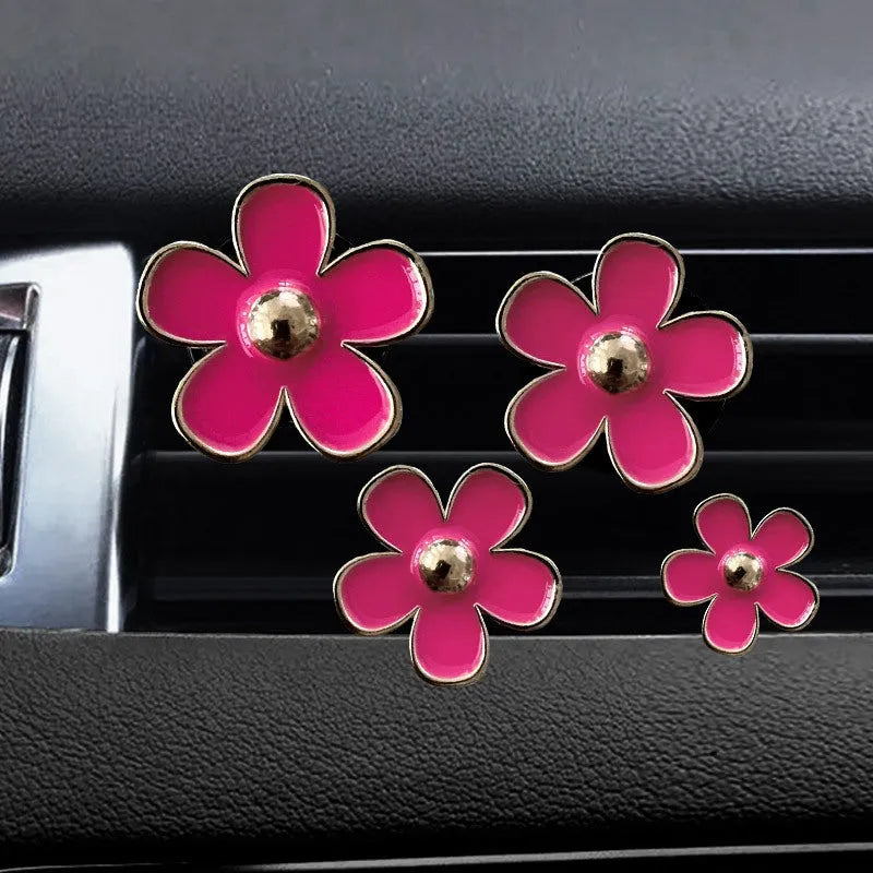 Set of four metal flower-shaped car vent aromatherapy clips in assorted colours