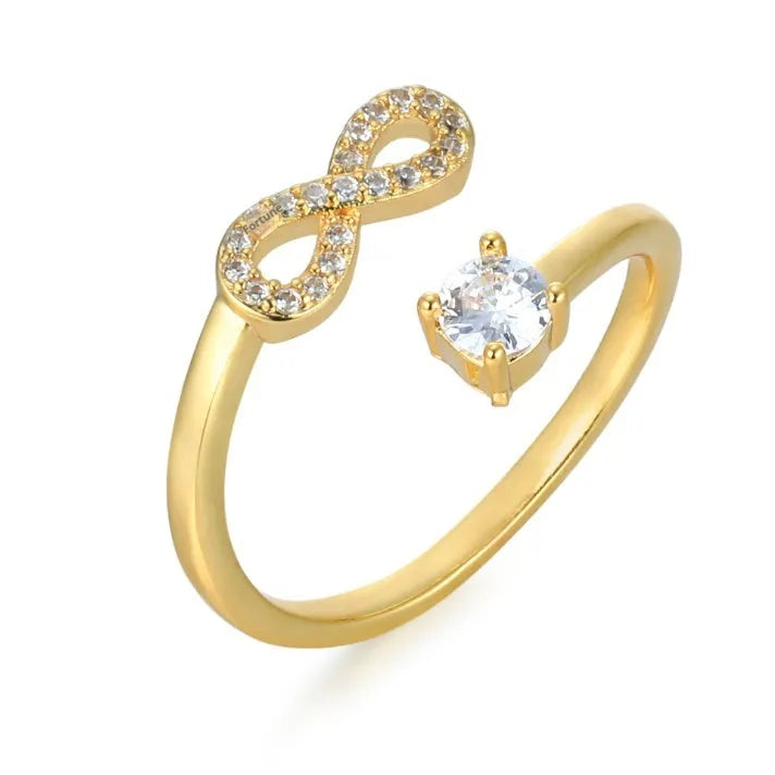 Gold metal open ring with diamond zircon letter design on a plain background