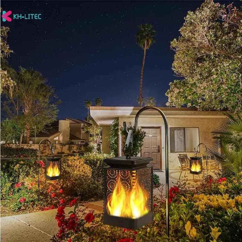 Set of four black solar-powered flame effect LED lanterns for outdoor garden decoration.