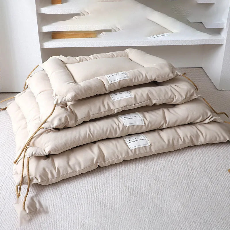 Beige pet cage cushion secured inside a metal dog crate, showing tie straps.