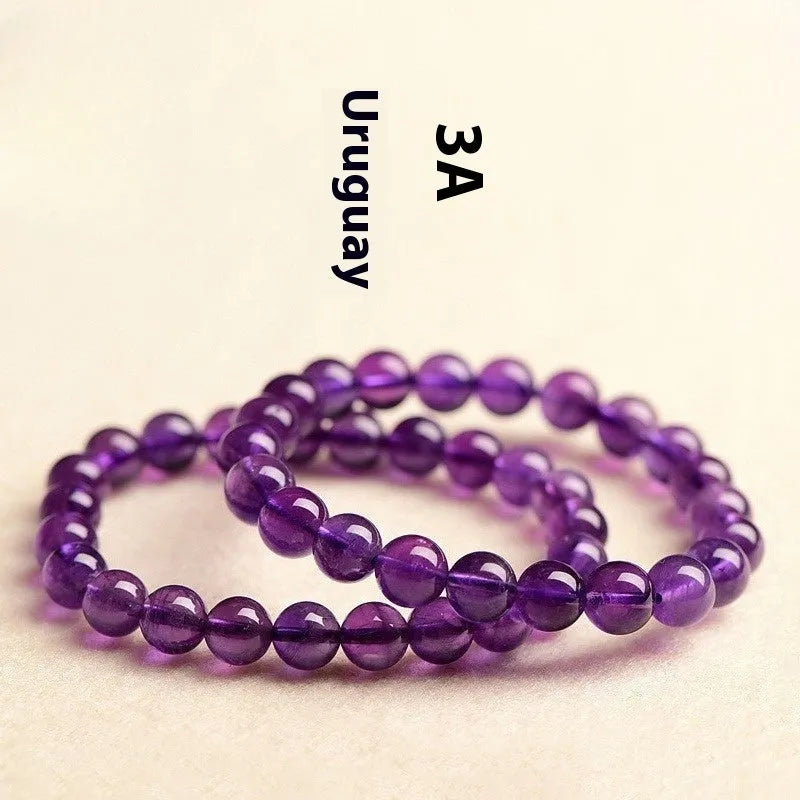Natural amethyst Uruguay bracelet with scattered polished beads on a white background.