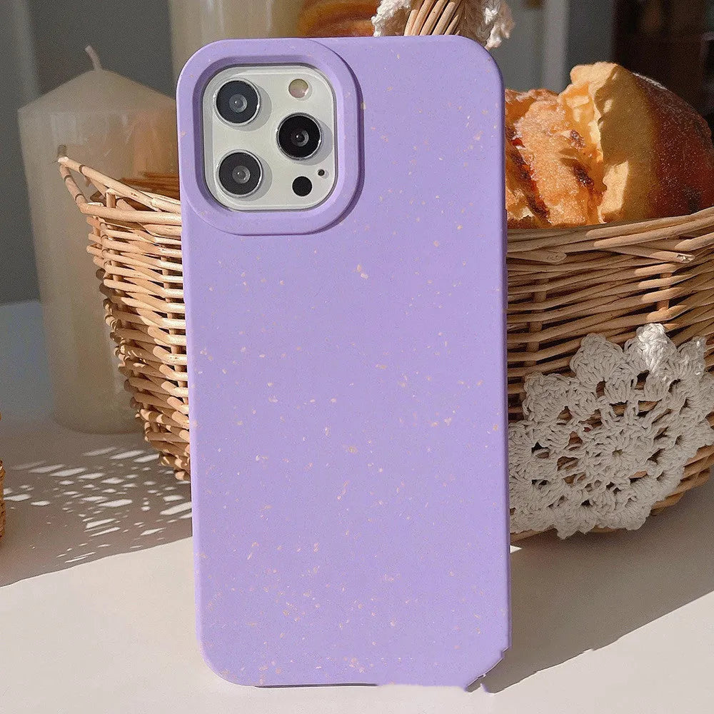 Degradable wheat straw phone case for Apple iPhone on a wooden surface.