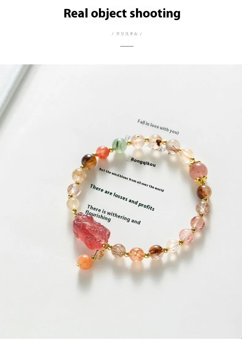 Copper women's bracelet with strawberry quartz crystal, Pixiu charm, and pearl accents on a white background.
