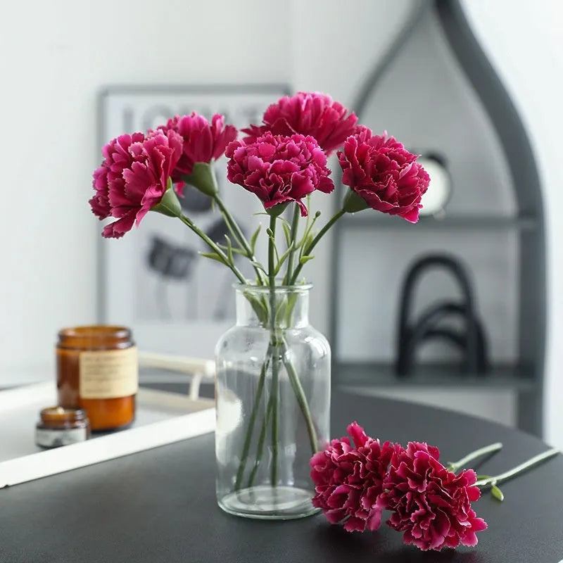 Single artificial mini carnation fake flower in soft rubber and silk material on white background