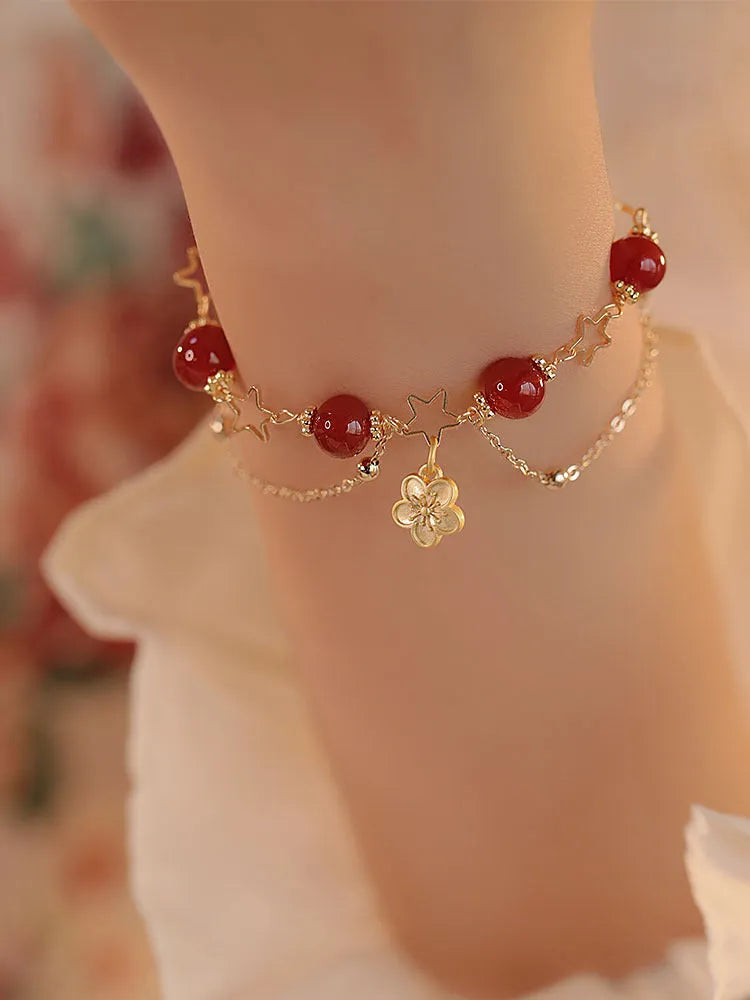Women's double layer bracelet made from natural red agate with peach blossom decorations.
