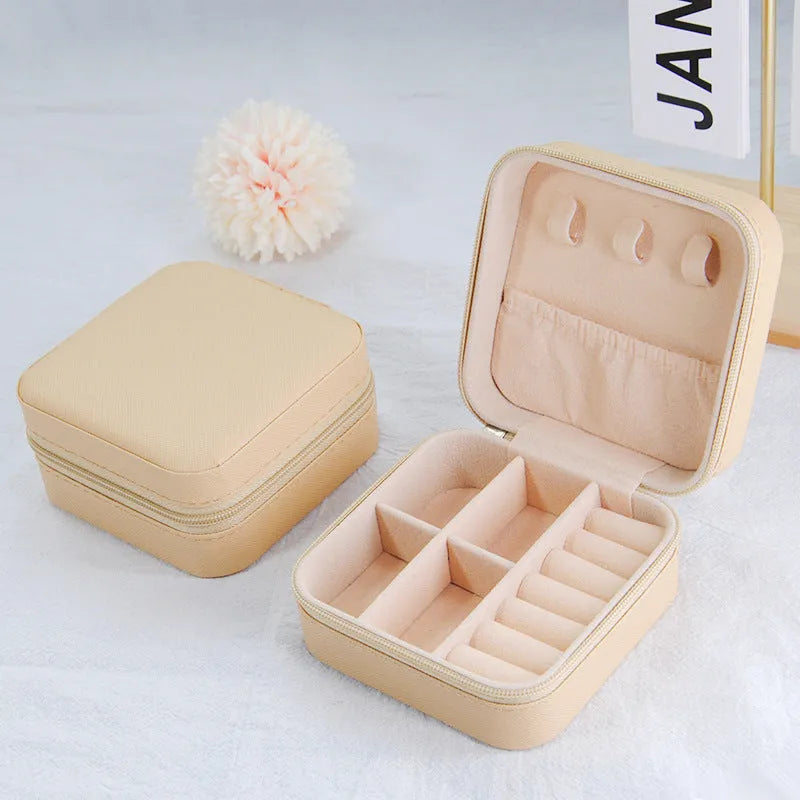 Small leather jewellery box in cross pattern, 10cm size, for earrings and rings, on a flat surface.