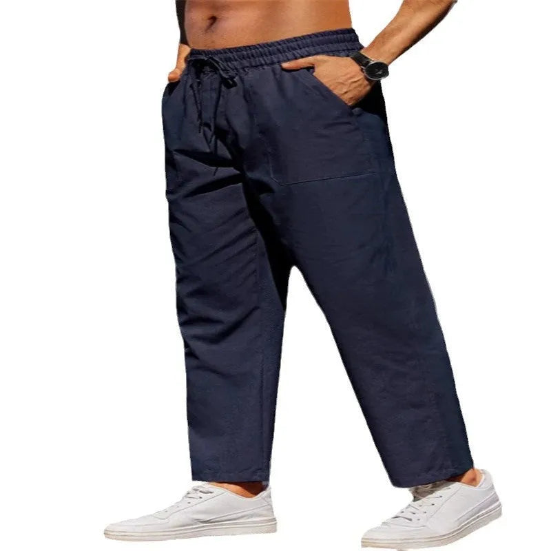 Men's straight-leg linen trousers in a solid colour, showing the elasticated mid waist and long leg.
