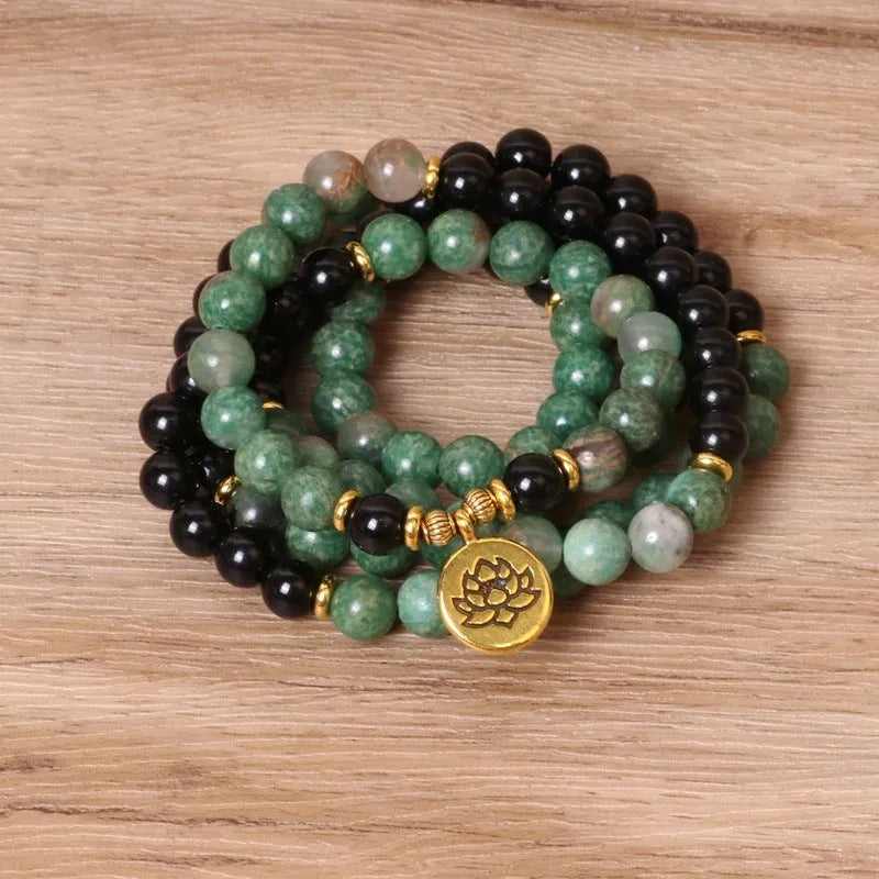 Green and black elastic beaded alloy bracelet on a wrist, showing its natural style and length.