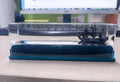 Fluid drift bottle with floating astronaut decoration in acrylic resin, black pearl pirate ship style, on a wooden desk.