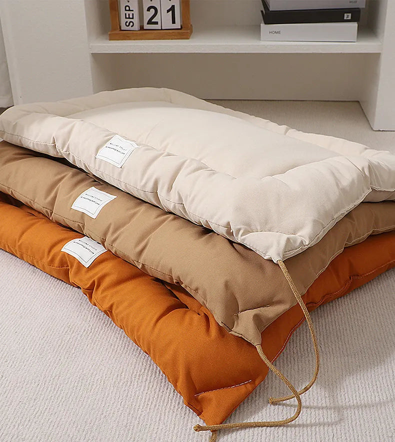Beige pet cage cushion secured inside a metal dog crate, showing tie straps.