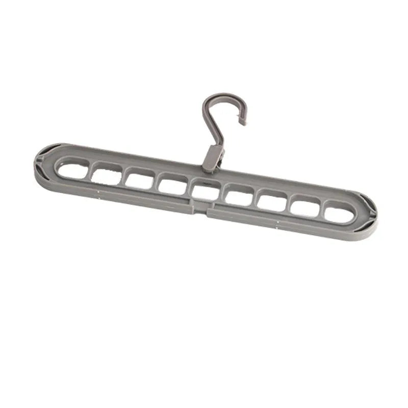 Green plastic nine-hole multifunctional clothes hanger for trousers on a white background.