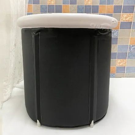 Black inflatable portable ice bath tub with weather lid, shown outdoors.