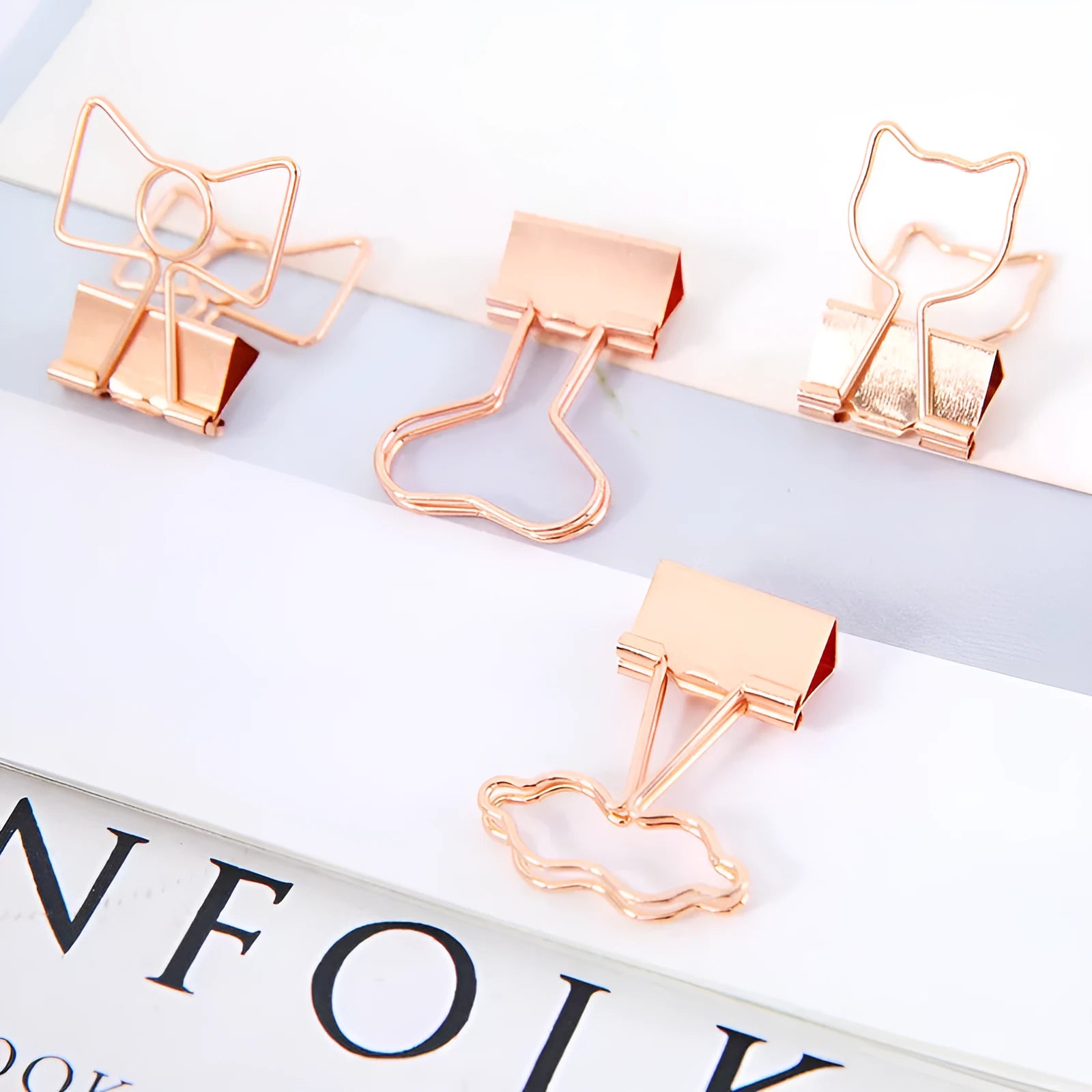 Small gold-plated metal office clip with a long tail, shown in a choice of flamingo, love, clouds, cat, and cactus shapes.