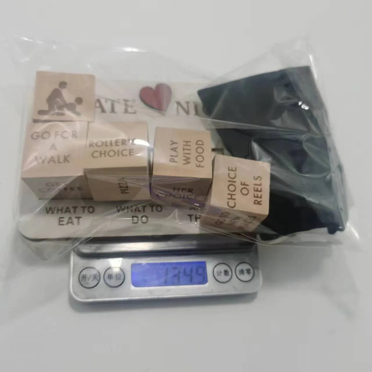 Wooden date night dice set showing five wooden dice, a rectangular planner board, and a black storage bag.