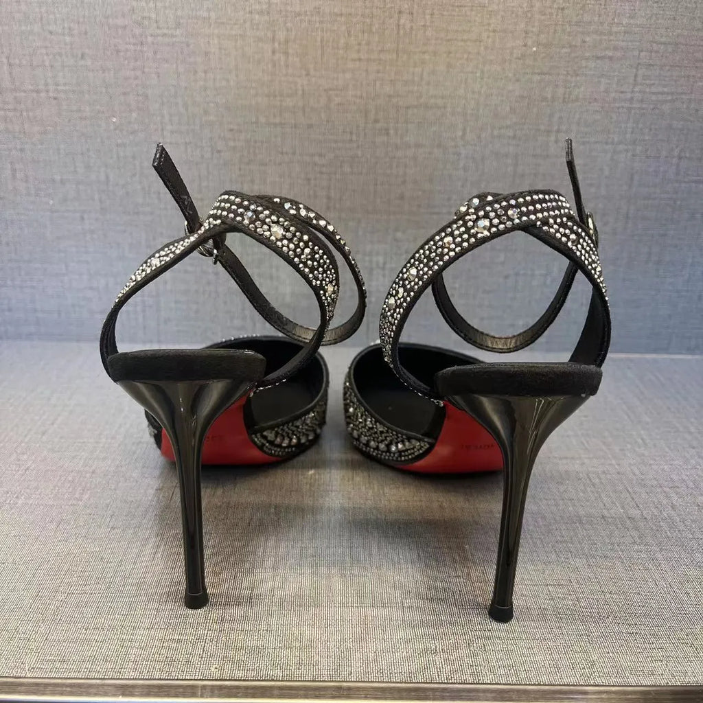 Black women's stiletto high heel shoe with a pointed toe and a bright red sole.