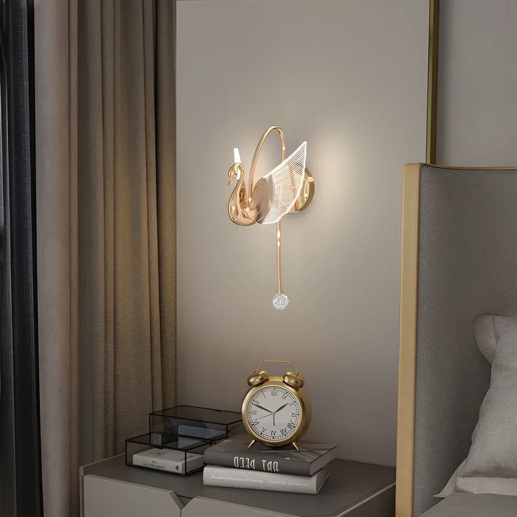 Modern gold swan-shaped wall lamp with white acrylic shade mounted on a wall.