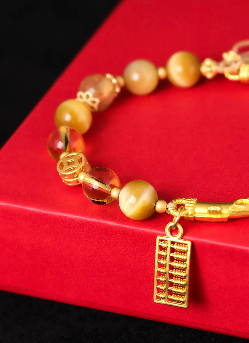 Women's beaded bracelet with tigereye, citrine, and yellow tower crystal beads in a diamond pattern.
