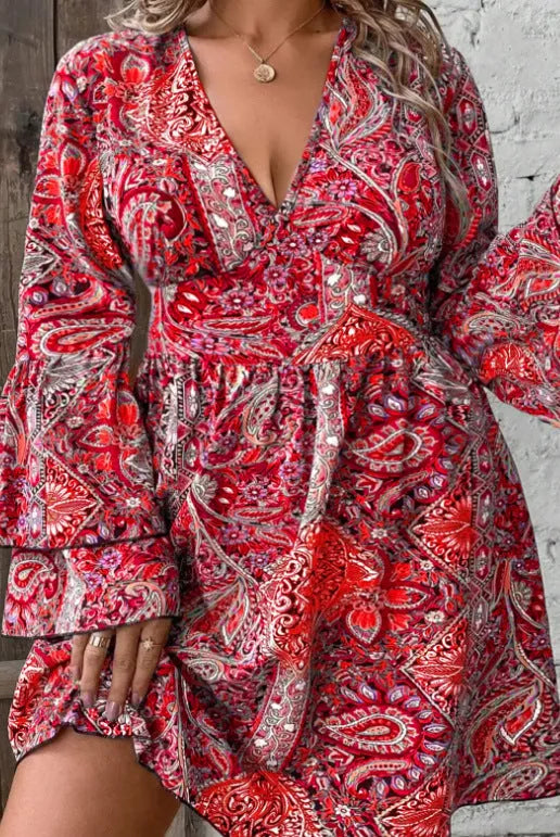 Women's plus size Bohemian style dress with V-neck, long bell sleeves, and an A-line short skirt in a solid colour.