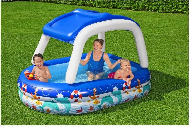 Boat type inflatable PVC sunshade paddling pool for children, 2.13m long, blue with yellow canopy, set up in garden