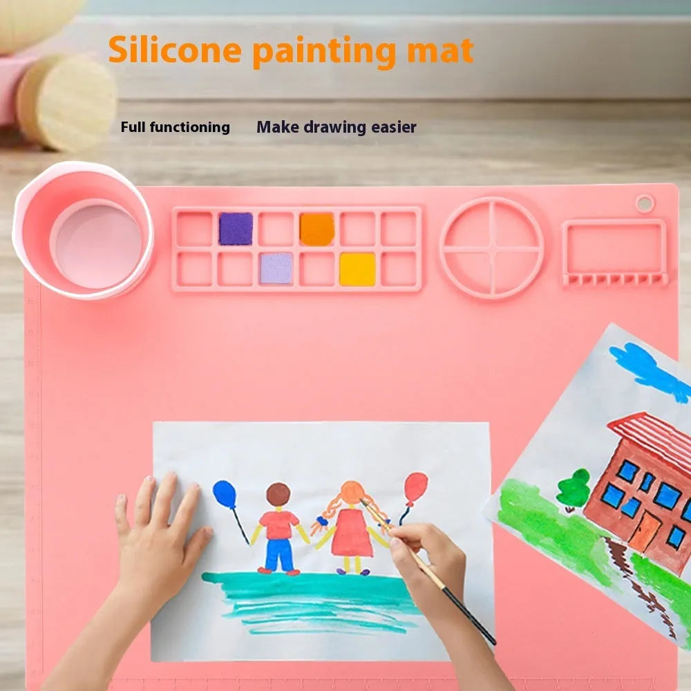 Light blue silicone painting mat with two moulded bowls for artists, size 50cm by 40cm.