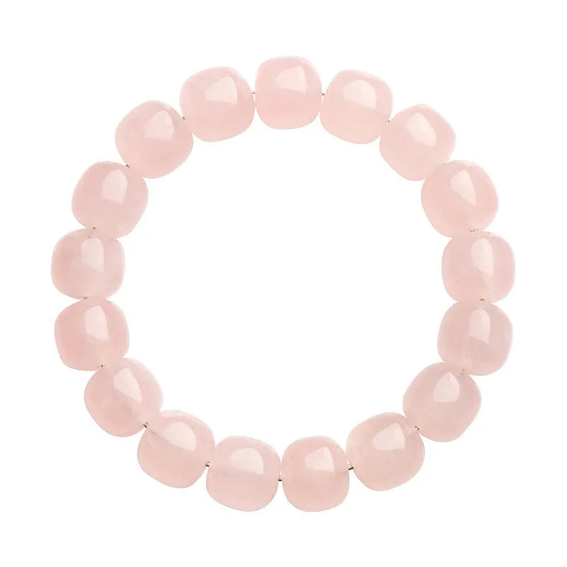Close-up of a pink geometric bracelet with barrel-shaped crystal beads on a wrist.