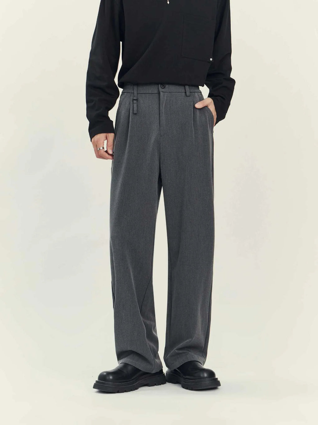 Men's black loose straight-leg business casual trousers on a hanger showing the draping style fit.