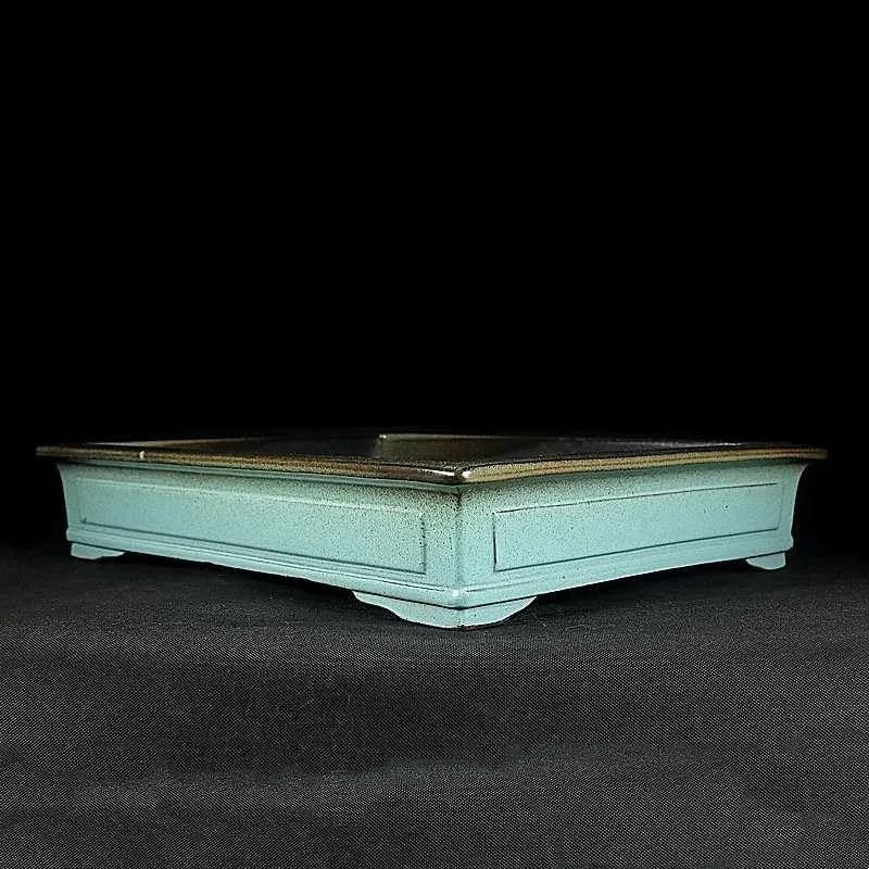 Handmade retro purple sand glaze ceramic bonsai flower pot in green colour on desktop