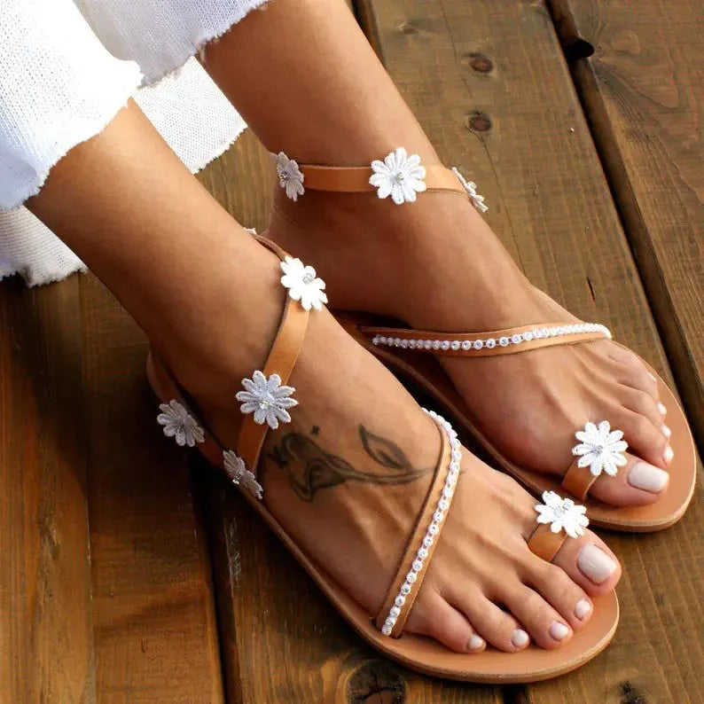 Brown women's floral Roman sandals with flat sole and slip-on design