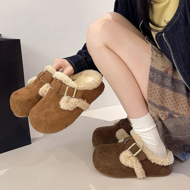 Baotou semi-drag fleece slippers in brown and camel with faux fur lining, closed toe, and rubber sole on a wooden floor